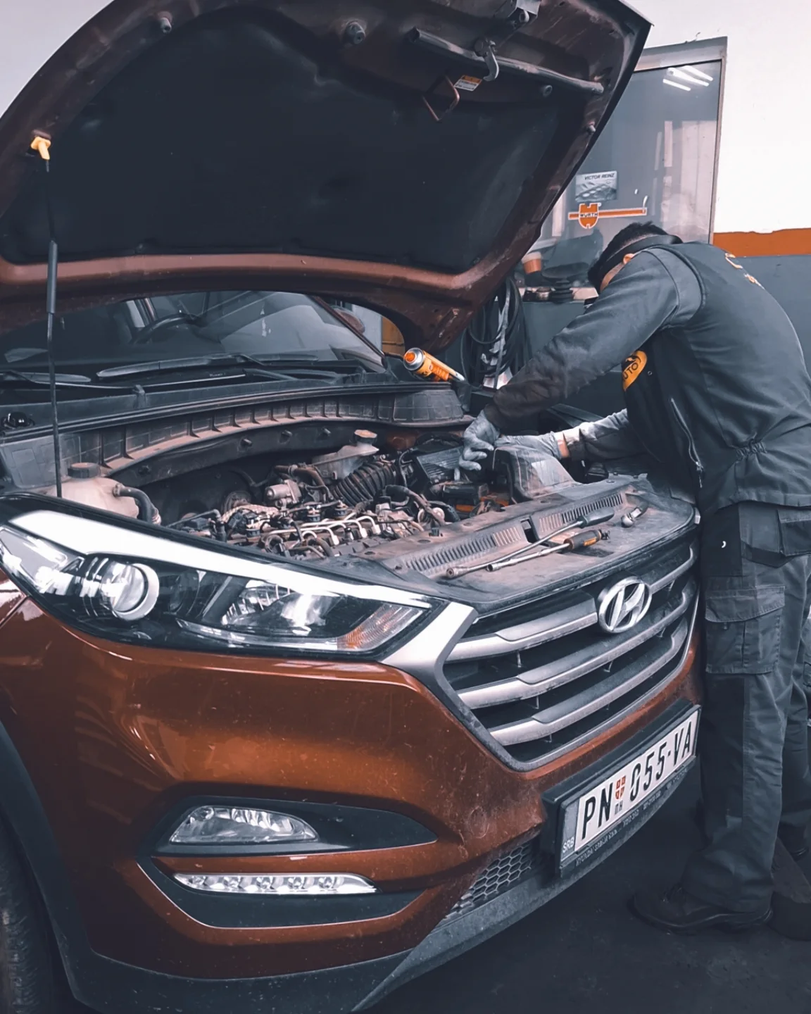 Majstor radi na motoru Hyundai Tucsona sa podignutom haubom